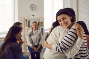 two people in a group hug after asking "how to find an inpatient drug rehab near seattle, wa?"