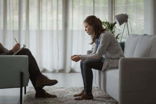 a person sits on a couch in therapy possibly asking what is cyclothymic disorder