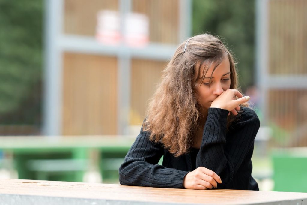 a person sits at a bench dealing with Dabbing withdrawal symptoms