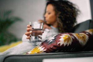a person drinks water as they try to how to sober up from being crossfaded