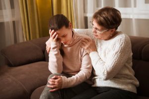 an older person comforts a younger person after learning how to support an alcoholic loved one