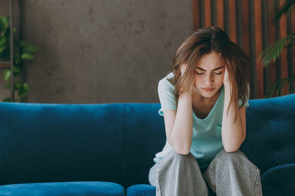 a person sits on a couch lamenting the side effects of oxycodone