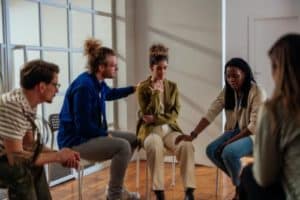 a group of people sit in a circle and participate in a depression treatment program