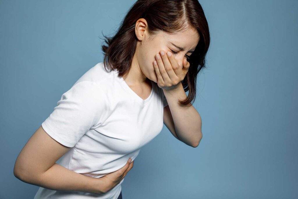 a person holds their stomach and mouth as they deal with dilaudid side effects