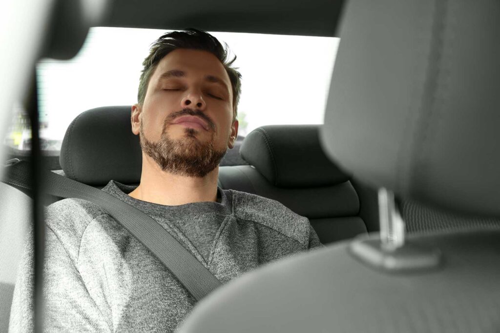 a person falls asleep in the back seat of a car as they deal with the long-term effects of flakka