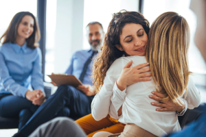 two people hug during group therapy in a residential treatment program