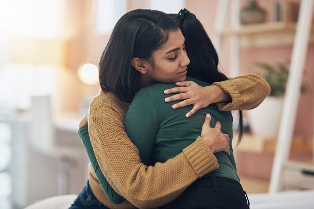 a person dealing with ketamine abuse hugs another as they offer supprot
