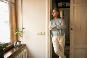 a person dealing with suboxone side effects stands in the doorway of a bathroom looking out a window