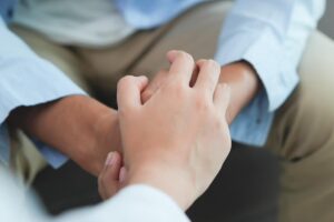a person comfort another by holding their hands and offering to find help for how to treat anxiety