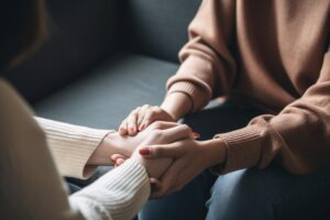 a person holds another's hands after recognizing signs they may need depression treatment